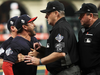 Dave Martinez #4 of the Washington Nationals argues with umpire Gary Cederstrom as he is ejected and is held back in Game Six of the 2019 World Series.