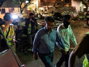 A man escorts a protester as he walks out to surrender to police at The Hong Kong Poytechnic University on November 24, 2019 in Hong Kong, China.