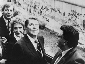 U.S. President Ronald Reagan (C), his wife Nancy (behind him), Bundestag President Philip Jenninger (R) and Berlin's mayor Eberhard Diepgen (L) are seen on the balcony of the "Reichstag" near to the Berlin wall, 12 June 1987 in West Berlin.