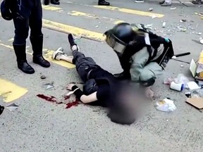 A police officer kneels over a protester who had just been shot during unrest in Hong Kong.