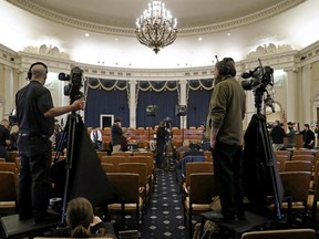 Journalists and camera crews report from inside the hearing room where the House Intelligence Committee will hold its first public impeachment hearing in the Longworth House Office Building on Capitol Hill November 13, 2019 in Washington, DC.