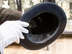 This file photo taken on November 20, 2019 shows a man holding a top hat with the initials "AH" from the J A Seidl hat manufacturer on November 20, 2019 in Grasbrunn near Munich, southern Germany, prior to an auction of personal belongings from German dictator Adolf Hitler and other notorious Second World War Nazi leaders.