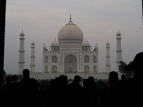 Tourists visit the Taj Mahal in smoggy conditions in Agra on November 6, 2019.