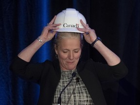 Infrastructure and Communities Minister Catherine McKenna puts on a hard hat during her speech to the Federation of Canadian Municipalities in Ottawa, Wednesday, Nov. 27, 2019.