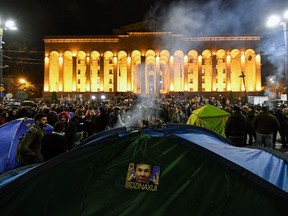 A picture of Bidzina Ivanishvili is seen attached to a tent set by protesters outside the parliament in central Tbilisi on November 15, 2019.