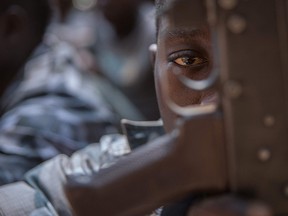 A newly released child soldier looks through a rifle trigger guard during a release ceremony in Yambio, South Sudan, on Feb. 7, 2018.