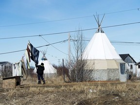 An indigenous women takes down laundry in the northern Ontario First Nations reserve in Attawapiskat, Ont., on April 19, 2016. A new national study that delves into First Nations nutrition has found obesity and diabetes rates among First Nations adults are significantly higher than the general Canadian population and that almost half of all First Nations families have difficulty putting enough food on the table.