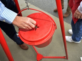 In this Nov. 9, 2018, file photo money gets dropped into the kettle during the Annual Salvation Army Red Kettle and Angel Tree Kick Off outside the Hobby Lobby store in Augusta, Ga. Canada's Salvation Army is testing out a new and faster way to allow cashless donations to its kettle stations via debit and credit card, making the process as quick and easy as dropping a toonie in the bubble.