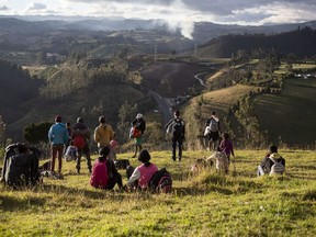 Venezuelan migrants look out from a grassy knoll at the Panamericana Highway, in Urbina, Ecuador, on August 27, 2019. The ripples from Venezuela's collapse are shifting Canada's Western Hemisphere neighbourhood, creating major long-term costs for the new Liberal minority government.