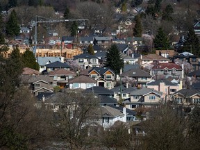 A condo building is seen under construction surrounded by houses in Vancouver, B.C., on Friday March 30, 2018. Housing sales in British Columbia are climbing faster than anticipated after a downturn, but a rebound won't be as inflamed as the sellers' market two years ago, says a report released Monday by Central 1 Credit Union.