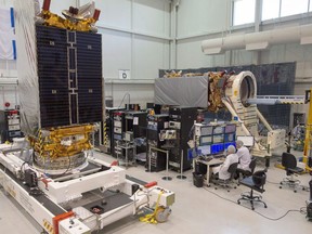 Technicians put the final touches on two of three Radarsat Constellation Mission satellites at the MDA facility Thursday, June 21, 2018 in Montreal. The federal government is looking at ways to better protect Canadian satellites from natural threats such as solar weather and space debris as well as cyberattacks, signal-jamming, lasers and anti-satellite missiles.THE CANADIAN PRESS/Ryan Remiorz