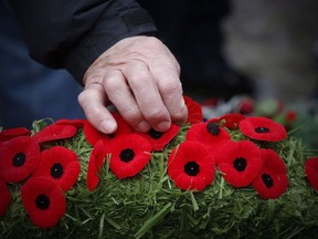 Poppies are placed on a wreath at a cenotaph during a Remembrance Day service in Winnipeg, Saturday, Nov. 11, 2017. Canadians will gather at cenotaphs and monuments across the country this morning to remember and honour those who took up arms - and in some cases paid the ultimate price - to defend this country and its way of life.THE CANADIAN PRESS/John Woods