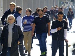 People make their way through the Financial District along Montgomery Street Friday, Oct. 18, 2019, in San Francisco. A new study is offering what it calls a rare look at the health and psychological impacts endured by Canadian youth who fall into the demographic category of not employed or not studying.