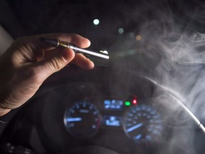 In this photo illustration, vapor from a cannabis oil vaporizer is seen as the driver is behind the wheel of a car in North Vancouver, Wednesday, Nov. 14, 2018.