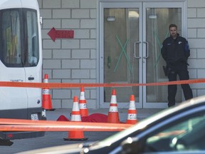 A police officer stands near the body of alleged mob boss Andrew Scoppa, who was shot to death, in Montreal, Monday, Oct. 21, 2019. While murders of organized crime members are nothing new in the city, retired detective Guy Ryan says Montreal is also witnessing a lot of what he called "disorganized crime."