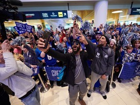 Winnipeg Blue Bombers Rasheed Bailey, left, and Kenny Lawler take selfies with fans as the team arrives at the Winnipeg James Armstrong Richardson International Airport on Monday, November 25, 2019 after winning the Grey Cup Sunday night.