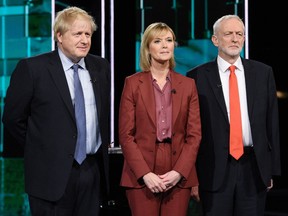 A handout picture taken and released by ITV on November 19, 2019, shows  Britain's Prime Minister Boris Johnson (L) and Britain's Labour Party leader Jeremy Corbyn (R) with host Julie Etchingham on the set of "Johnson v Corbyn: The ITV Debate" in Salford, north-west England.