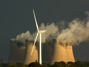 Wind turbines generate electricty in the shadow of Drax, a former coal-fired plant that reduced its coal use by converting to wood pellets, in the U.K.