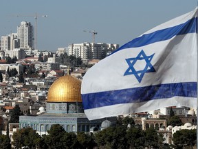 The Israeli flag flutters in front of the Dome of the Rock mosque and the city of Jerusalem.