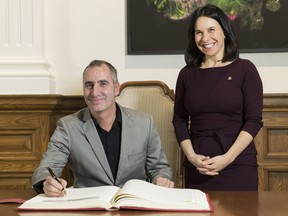 Erick Marciano signs the Golden Book alongside Montreal Mayor Valerie Plante at City Hall in Montreal, Monday, November 18, 2019. Marciano used his SUV to block a getaway car from potentially plowing into pedestrians at busy intersection in Montreal.