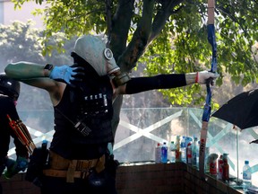 An anti-government protester uses a bow during clashes with police outside Hong Kong Polytechnic University, in Hong Kong, China, November 17, 2019.