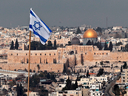 An Israeli flag flies on the roof of a building in East Jerusalem.