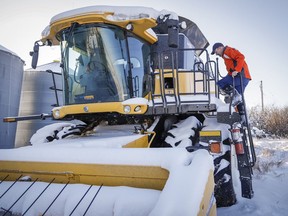 Farmer David Reid checks on his combine while his crops are buried under snow near Cremona, Alta., Wednesday, Nov. 6, 2019.