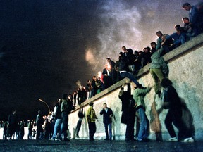 People climb the Berlin Wall at the Brandenburg Gate after the opening of the East German border on Nov. 9, 1989.