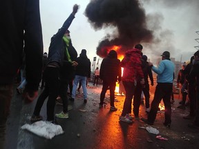 Iranian protesters gather around a fire during a demonstration against an increase in gasoline prices in the capital, Tehran, on Nov. 16, 2019.