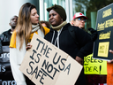 Kikome Afisa, right, is comforted as she along with others protest outside the Federal Court of Canada building for a hearing of the designation of the U.S. as a safe third country for refugees in Toronto on Nov. 4, 2019.