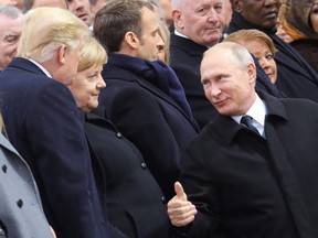 Russian President Vladimir Putin (R), talks with German Chancellor Angela Merkel (C) and US President Donald Trump as they attend a ceremony at the Arc de Triomphe in Paris on November 11, 2018 as part of commemorations marking the 100th anniversary of the 11 November 1918 armistice, ending World War I.