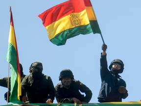 Policemen in rebellion wave a Bolivian national flag as they demonstrate at their headquarters in Cochabamba, in centre Bolivia, on November 9, 2019. Police in three Bolivian cities joined anti-government protests Friday, in one case marching with demonstrators in La Paz, in the first sign security forces are withdrawing support from President Evo Morales after a disputed election that has triggered riots.