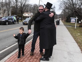 A member of Rabbi Chaim Rottenberg's community (R) hugs a well wisher in front of the rabbi's house on Dec. 29, 2019 in Monsey, New York.