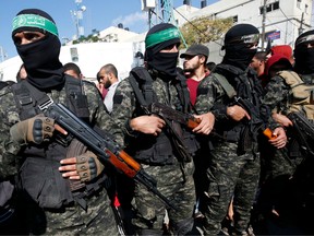 Palestinian militants of the Islamist movement Hamas' military wing Al-Qassam Brigades, attend the funeral of seven Palestinians, killed during an Israeli special forces operation in the Gaza Strip, on November 12, 2018, in Khan Younis.