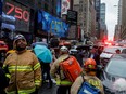 Fire Department of New York (FDNY) personnel and New York Police Department (NYPD) officers work at the scene as a woman was reported dead after debris fell on her near Times Square in Manhattan, New York, U.S., December 17, 2019.