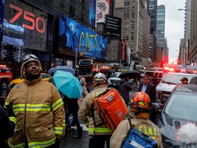 Fire Department of New York (FDNY) personnel and New York Police Department (NYPD) officers work at the scene as a woman was reported dead after debris fell on her near Times Square in Manhattan, New York, U.S., December 17, 2019.