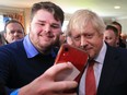 U.K. Prime Minister Boris Johnson poses for a selfie with supporters on a visit to meet newly elected Conservative party MP for Sedgefield, Paul Howell at Sedgefield Cricket Club on December 14, 2019 in County Durham, England.