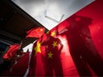 Pro-China counter-protesters cast shadows on a Chinese flag as they shout at Hong Kong anti-extradition bill protesters holding a rally, in Vancouver, on Saturday August 17, 2019.