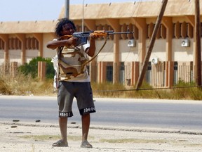 A fighter loyal to the internationally recognized Government of National Accord (GNA) points his gun toward enemy lines during clashes with forces loyal to strongman Khalifa Haftar, in Espiaa, about 40 kilometres  south of the Libyan capital Tripoli on Aug. 21, 2019.