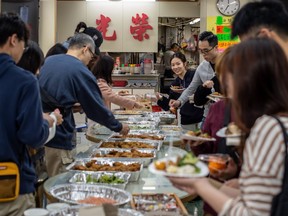 People enjoy a free Christmas dinner in a cafe in Tsim Sha Tsui district in Hong Kong on Dec. 25, 2019.