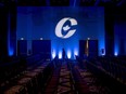A man is silhouetted while walking past a Conservative party logo prior to the opening of a national convention in Halifax on Aug. 23, 2018.