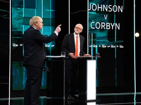 A handout picture taken and released by ITV on November 19, 2019, shows  Britain's Prime Minister Boris Johnson (L) and Britain's Labour Party leader Jeremy Corbyn (R) as they debate on the set of "Johnson v Corbyn: The ITV Debate" in Salford, north-west England.