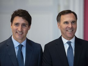 Prime Minister Justin Trudeau stands with Bill Morneau as he remains Minister of Finance during the swearing in of the new cabinet at Rideau Hall in Ottawa on Wednesday, Nov. 20, 2019. The Conservatives are calling on Finance Minister Bill Morneau to deliver an "urgent" fall economic update, including a plan to get back to balance.