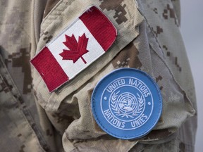 The Canadian and UN flags are seen on the shoulder of a Canadian soldier's uniform before boarding a plane at CFB Trenton in Trenton, Ont., Thursday, July 5, 2018. Canada's Defence Minister says Canada is exploring the possible deployment of military engineers as the Liberal government considers ways to step up its support to United Nations' peacekeeping.