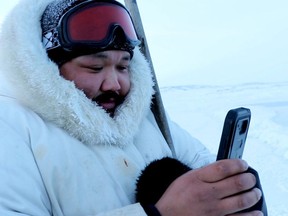 Puasi Ippak tests out the Siku mobile app in a handout photo. A social media app geared towards the outdoor lives of Inuit launched Wednesday with features that tie traditional knowledge to smart phone technology. THE CANADIAN PRESS/HO-Arctic Eider Society MANDATORY CREDIT