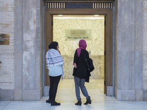 Two women wearing a hijabs wait in the lobby of the Quebec Court of Appeal in Montreal, Tuesday, Nov. 26, 2019. The Quebec Court of Appeal has rejected a request to suspend the central elements of the province's secularism law.