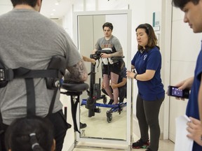 Physiotherapists help Ryan Straschnitzki perform standing exercises following his epidural implant surgery at World Health Hospital in Nonthaburi, Thailand on Friday, December 6, 2019.