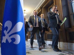 Quebec Premier Francois Legault, centre, walks to questions period, Saturday December 7, 2019 in Quebec City. After a tumultuous session in the legislature, Quebec Premier Francois Legault is making a swing through Silicon Valley and Hollywood, where the future of the carbon market will figure at the top of his agenda.