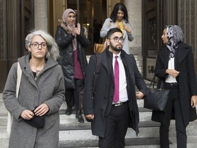 Members of the National Council of Muslims Mustafa Farooq, centre, and Bochra Manai, left, alongside supporters leave the Quebec Court of Appeal in Montreal, Tuesday, Nov. 26, 2019, where they are challenging Quebec's Bill 21.