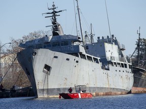 Canadian Coast Guard officers cruise their boat past Cormorant, the former Royal Canadian Navy diving support ship decommissioned in 1997, in Bridgewater, N.S. on Sunday, Dec. 1, 2019.